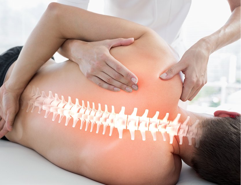 Ostheopath manipulating a patient's back with glowing spine illustration